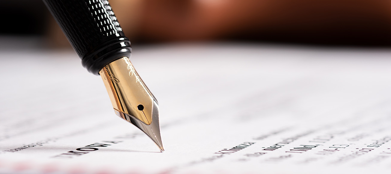 A fountain pen being used to sign a will on a desk close up; Broward County Wills Lawyer concept image