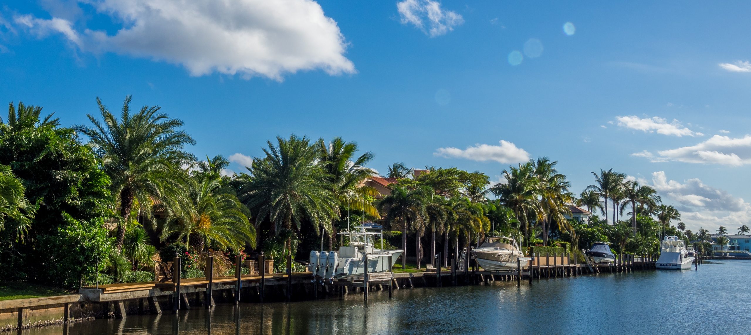 A broward county beautiful sub-tropic Broward county bay with lush palm trees, crystal blue water and blue sunny sky; Trusted Estate Planning Lawyer in Broward County FL concept image